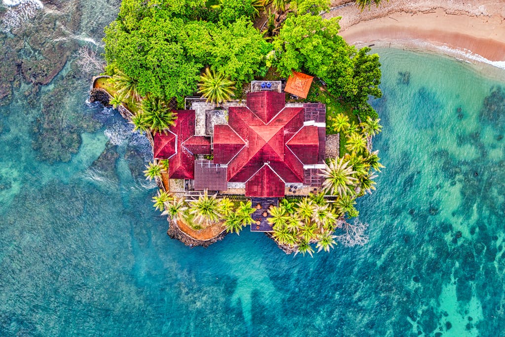 Stunning aerial shot of a house surrounded by turquoise water and lush greenery in Banten, Indonesia.