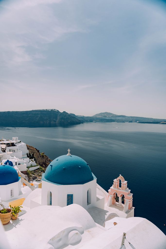 Greece's Santorini with blue domes and sea, perfect summer getaway.