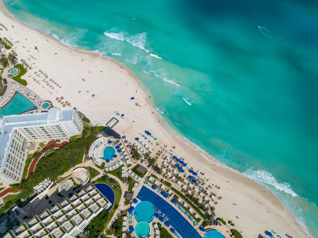 Stunning aerial view of Cancun's beachfront resort with turquoise waters and sandy shores.